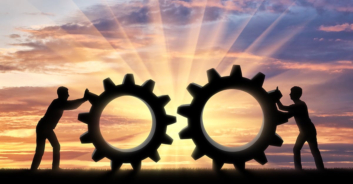 Two people pushing giant gears to symbolize software development productivity